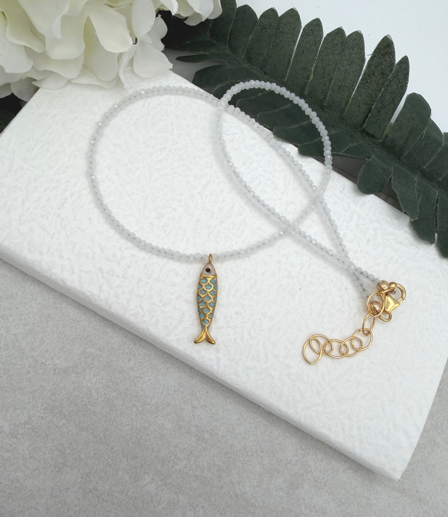 Necklace with Tiny, White Cryatls Beads and a Gold Plated, Enamled Fish Charm GCDN-210
