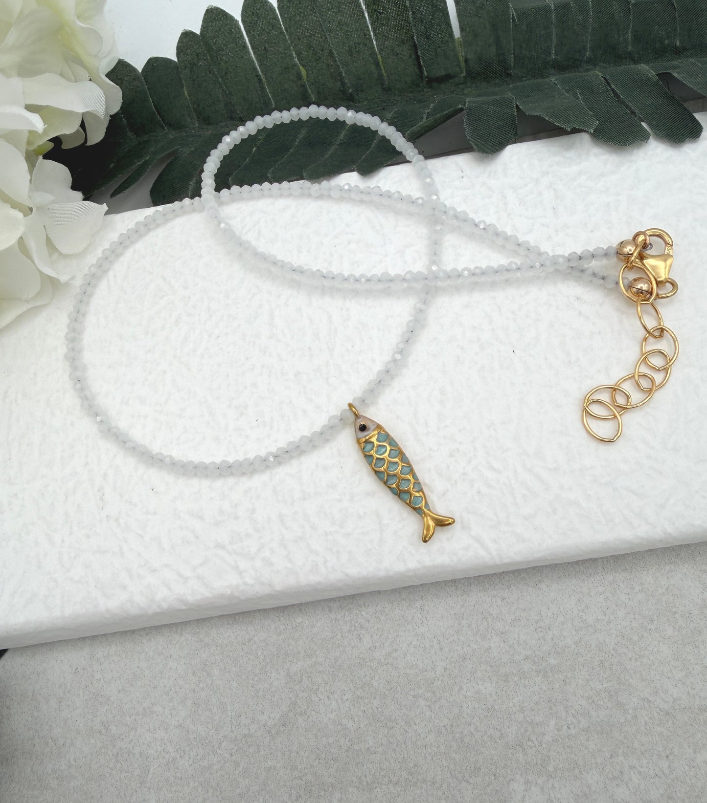 Necklace with Tiny, White Cryatls Beads and a Gold Plated, Enamled Fish Charm GCDN-210