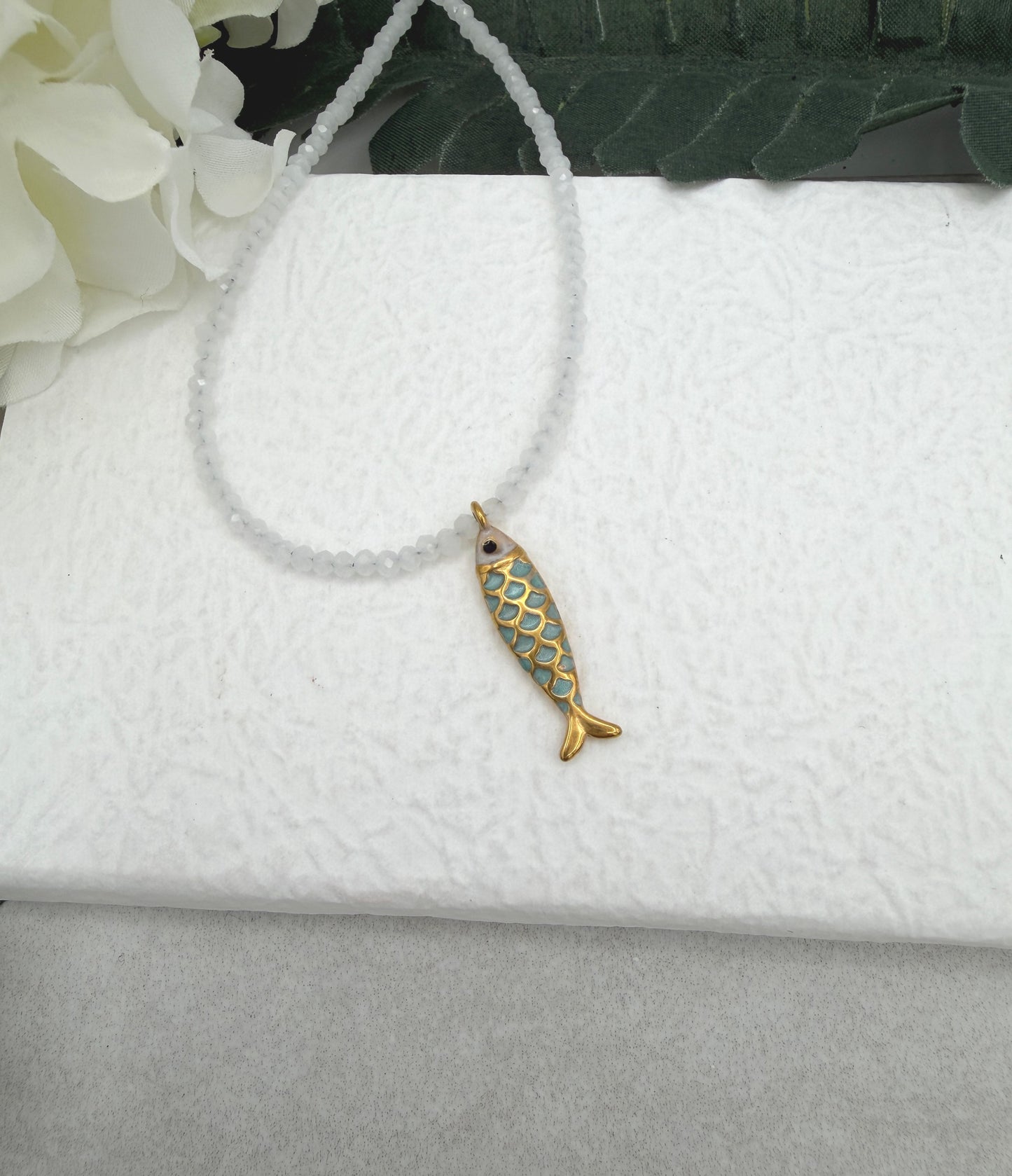 Necklace with Tiny, White Cryatls Beads and a Gold Plated, Enamled Fish Charm GCDN-210