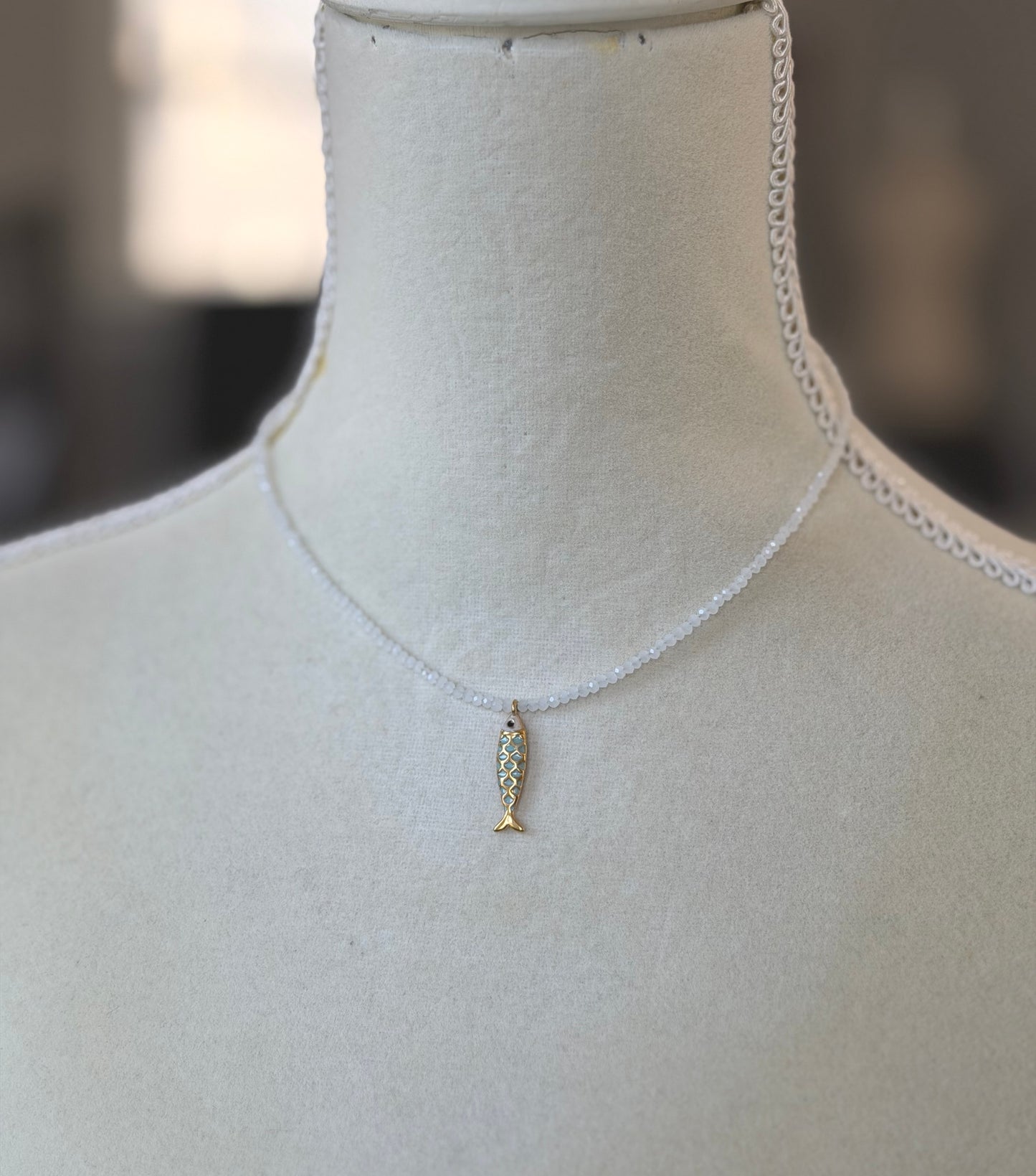 Necklace with Tiny, White Cryatls Beads and a Gold Plated, Enamled Fish Charm GCDN-210