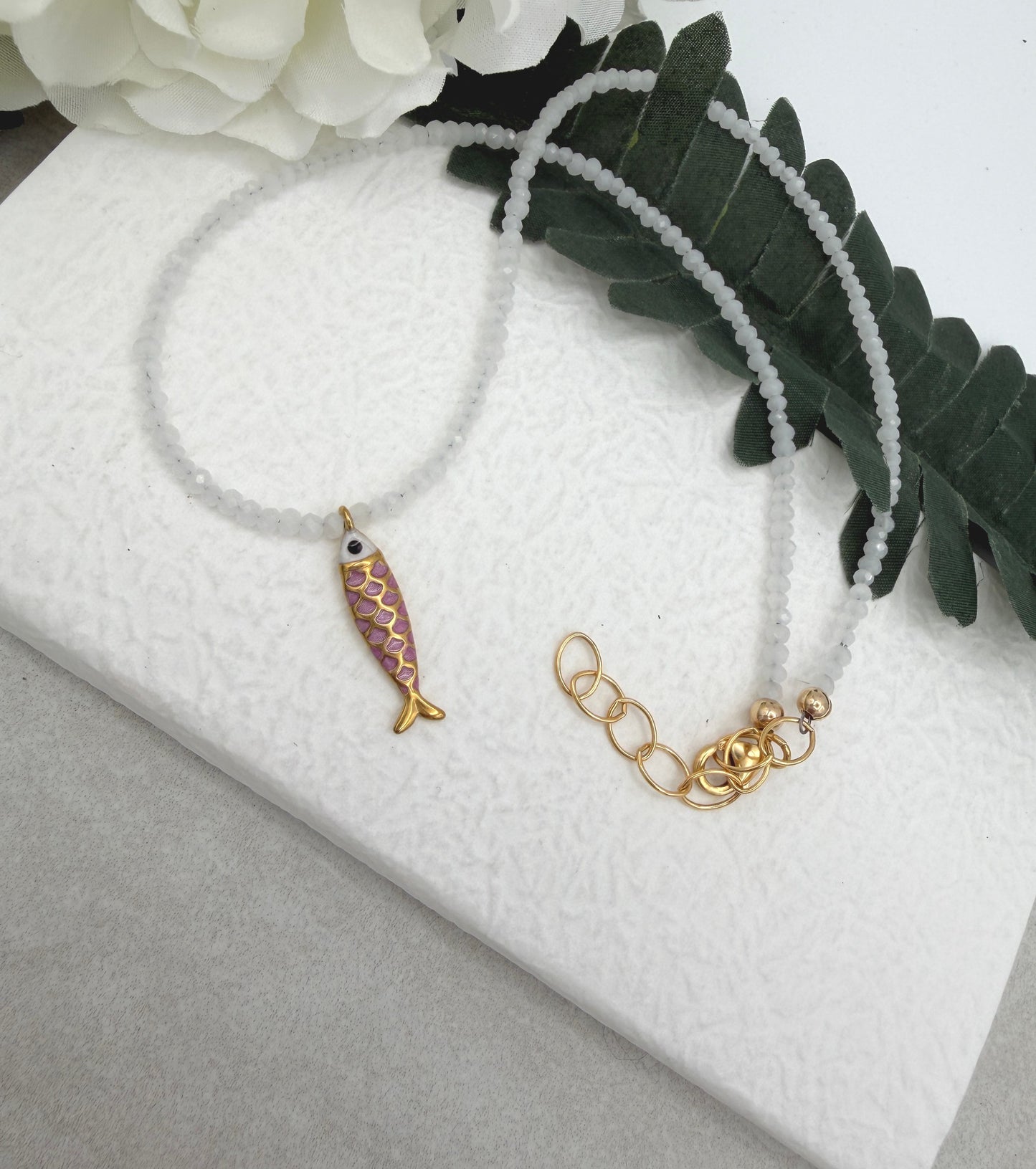 Necklace with Tiny, White Cryatls Beads and a Gold Plated, Pink Enamled Fish Charm GCDN-213