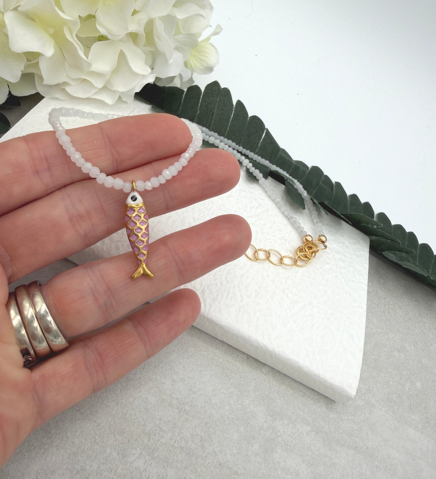 Necklace with Tiny, White Cryatls Beads and a Gold Plated, Pink Enamled Fish Charm GCDN-213