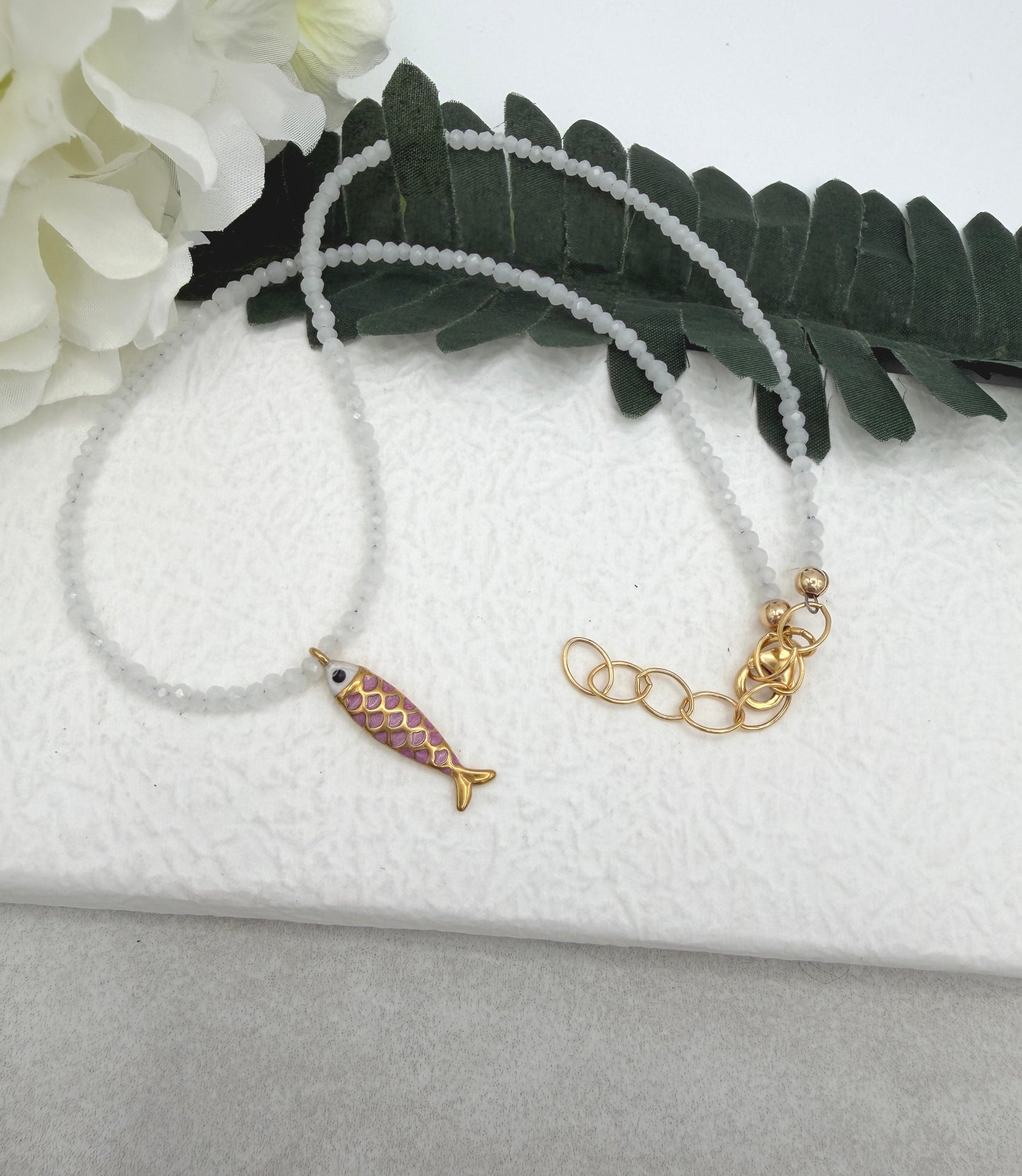 Necklace with Tiny, White Cryatls Beads and a Gold Plated, Pink Enamled Fish Charm GCDN-213