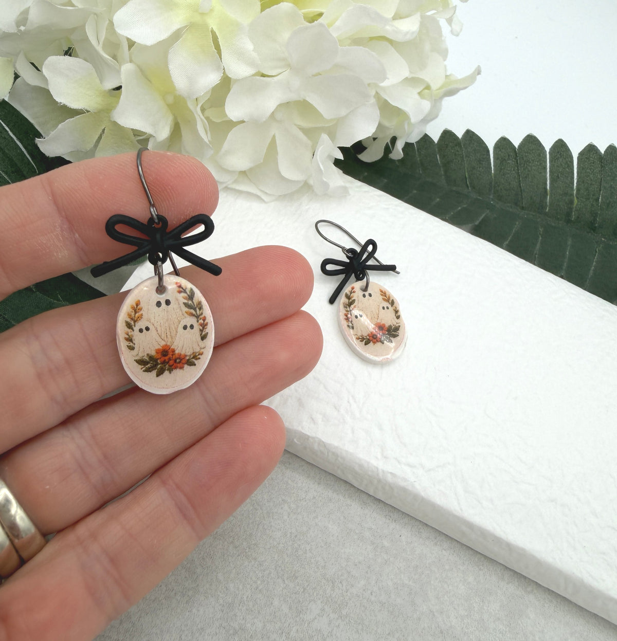 Earrings Made with Black Bow LInks and Polymer Clay Ovals with a Ghost Design and Oxidized Silver Earring Wires PCE-1084