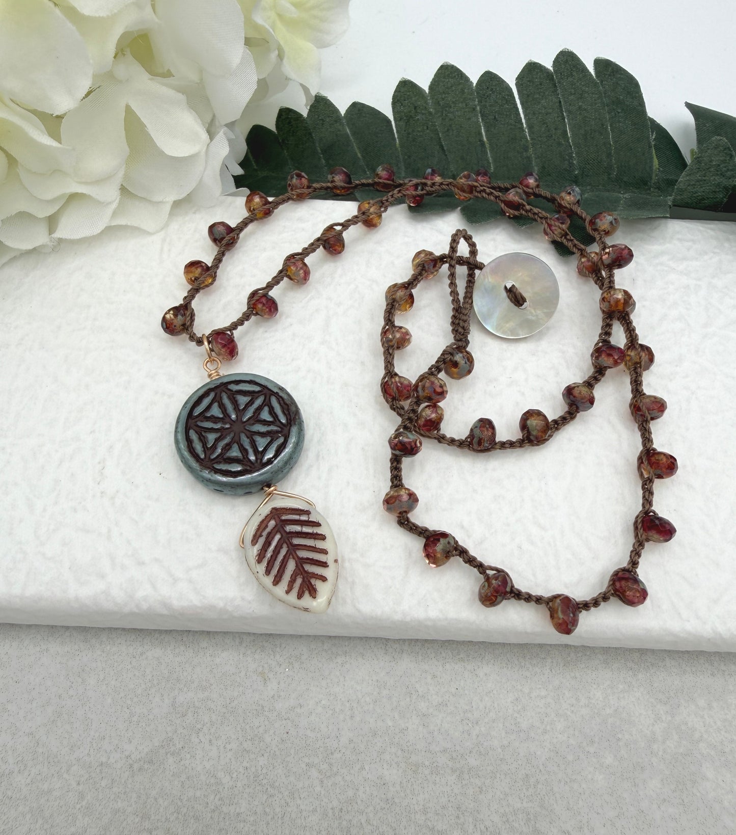 Crocheted Necklace with a Brown Cord, Red Brown Rondelles, Blue Green Flower of Life Bead and Cream Brown Leaf Bead SN-680