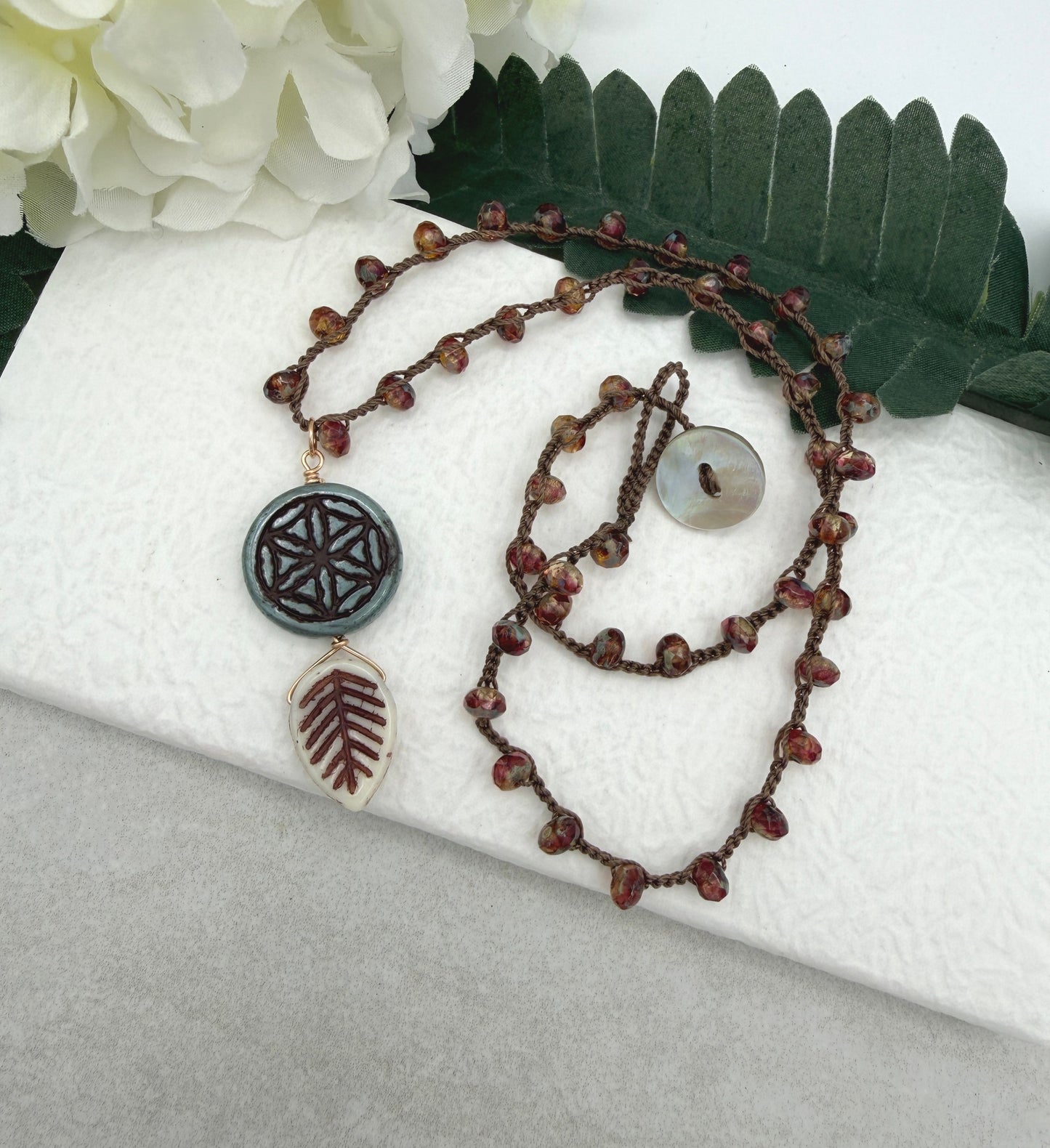 Crocheted Necklace with a Brown Cord, Red Brown Rondelles, Blue Green Flower of Life Bead and Cream Brown Leaf Bead SN-680