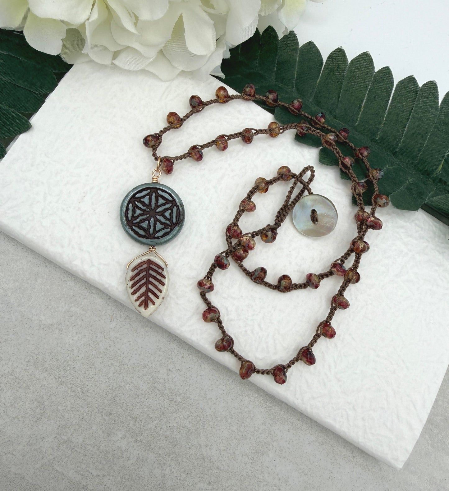 Crocheted Necklace with a Brown Cord, Red Brown Rondelles, Blue Green Flower of Life Bead and Cream Brown Leaf Bead SN-680