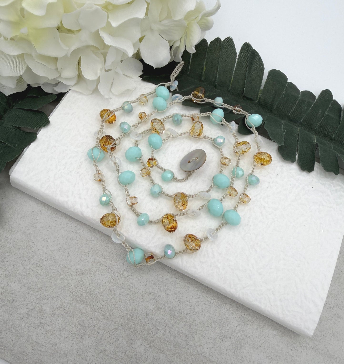 A Long Crocheted Necklace with an Ivory Cord With Aqua, Gold and Mily White Czech Glass Ronds SN-685