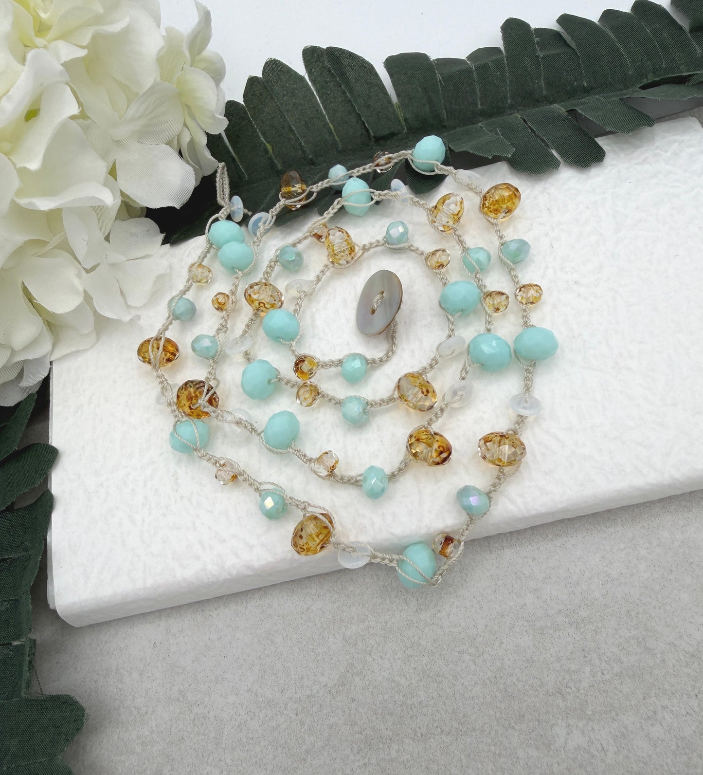 A Long Crocheted Necklace with an Ivory Cord With Aqua, Gold and Mily White Czech Glass Ronds SN-685