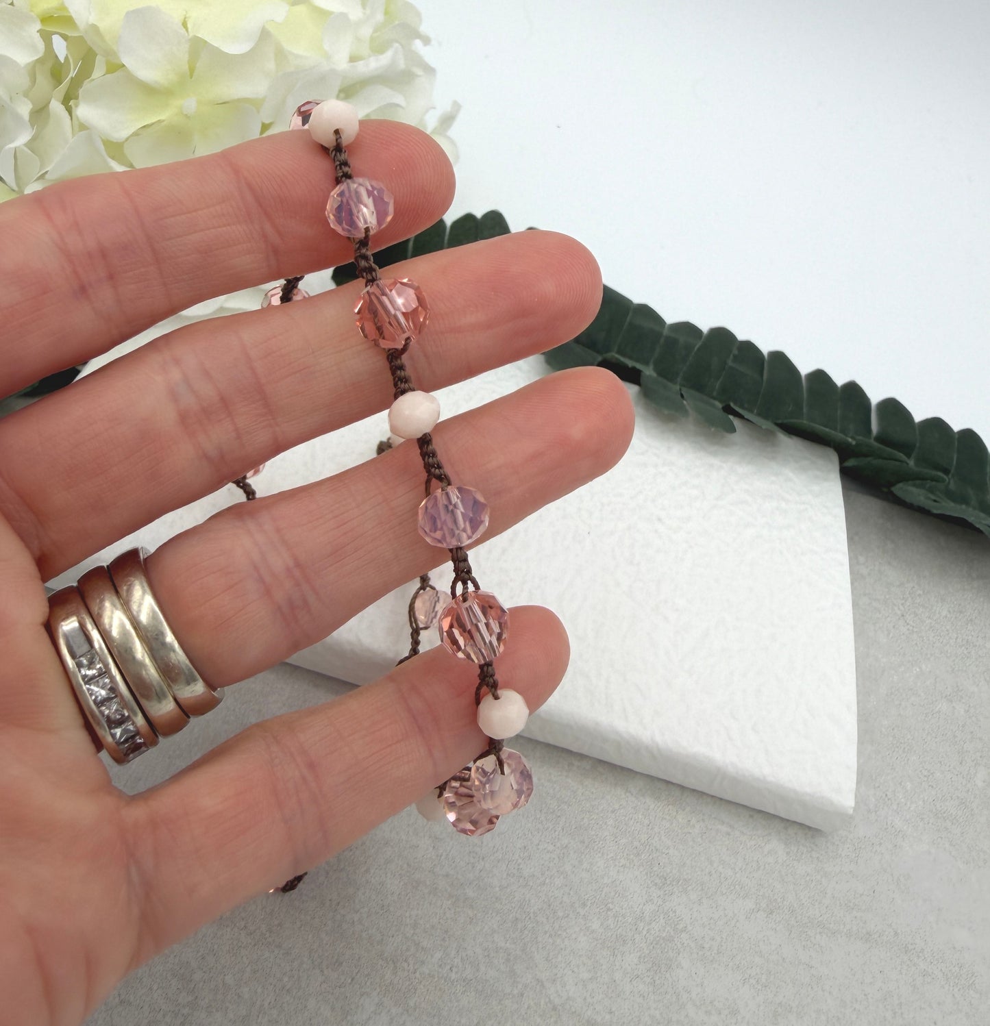 A Crocheted Necklace with a Brown Cord With Pink, Peach and Cream Crystal Beads SN-690