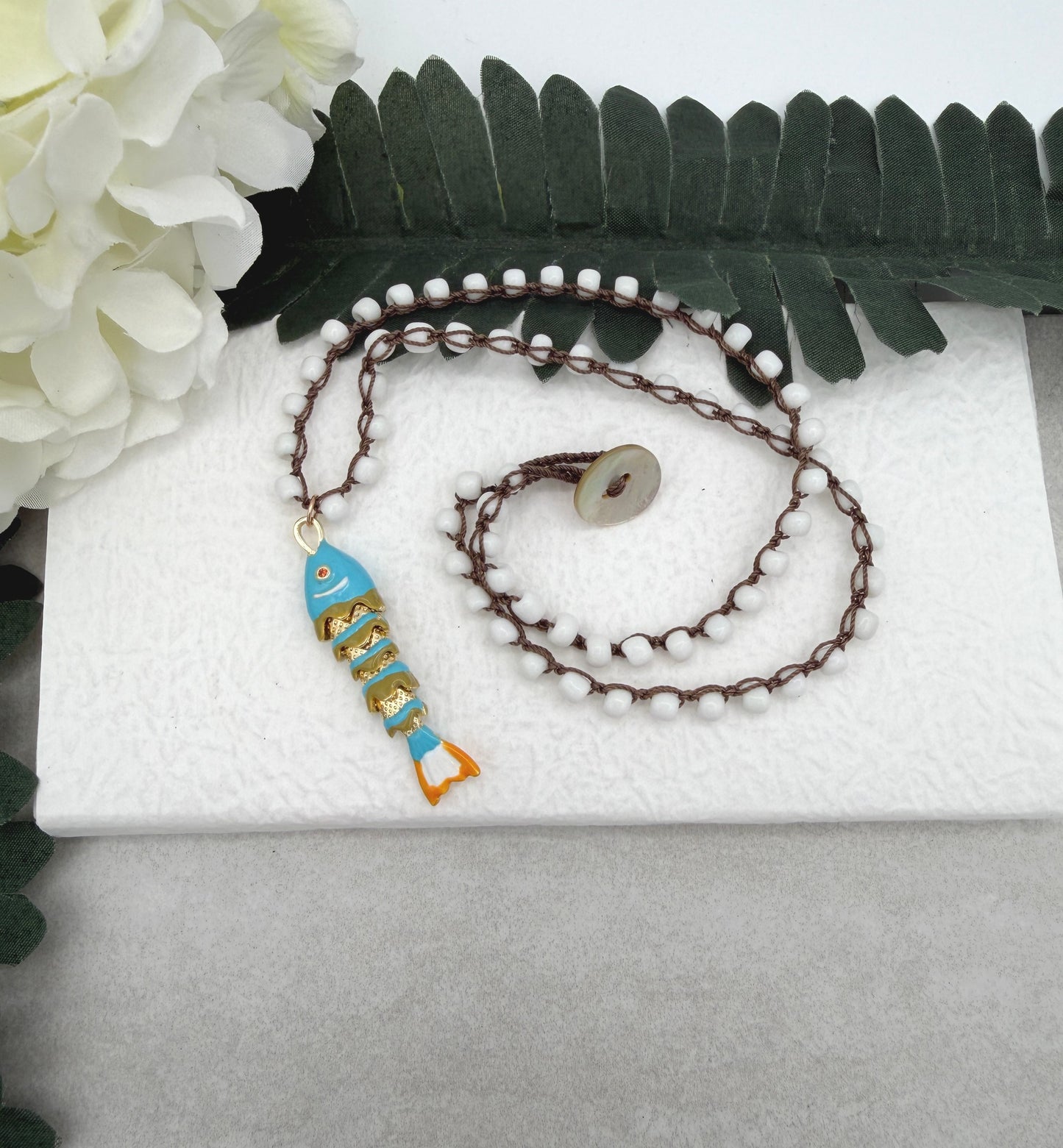 Crocheted Necklace with a Brown Cord, White Glass Beads and a Turquoise, Orangle Enameled Fish Charm SN-695
