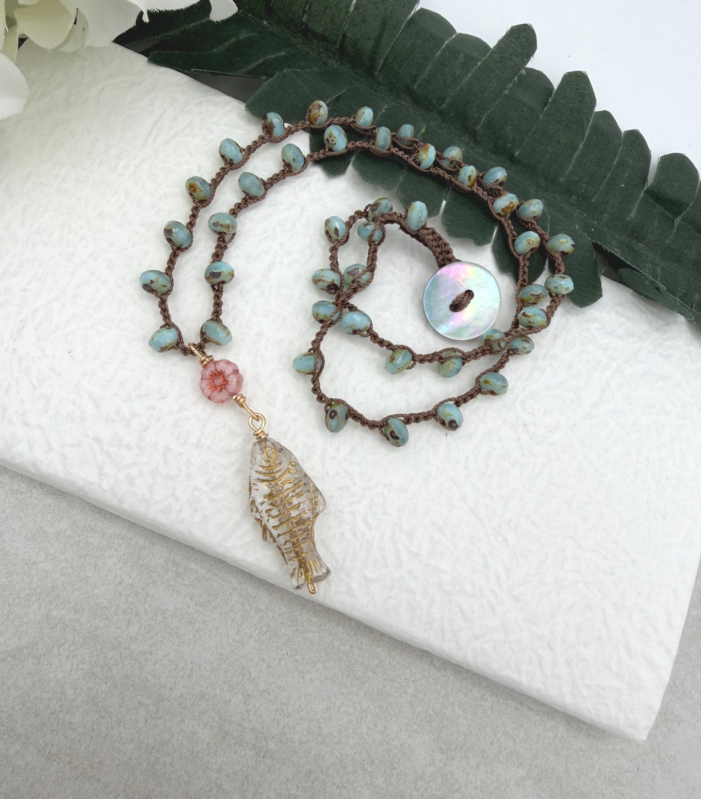 Crocheted Necklace with a Brown Cord, Blue Glass Beads, a Czech Glass Pink Flower, and Gold Glass Fish Bead