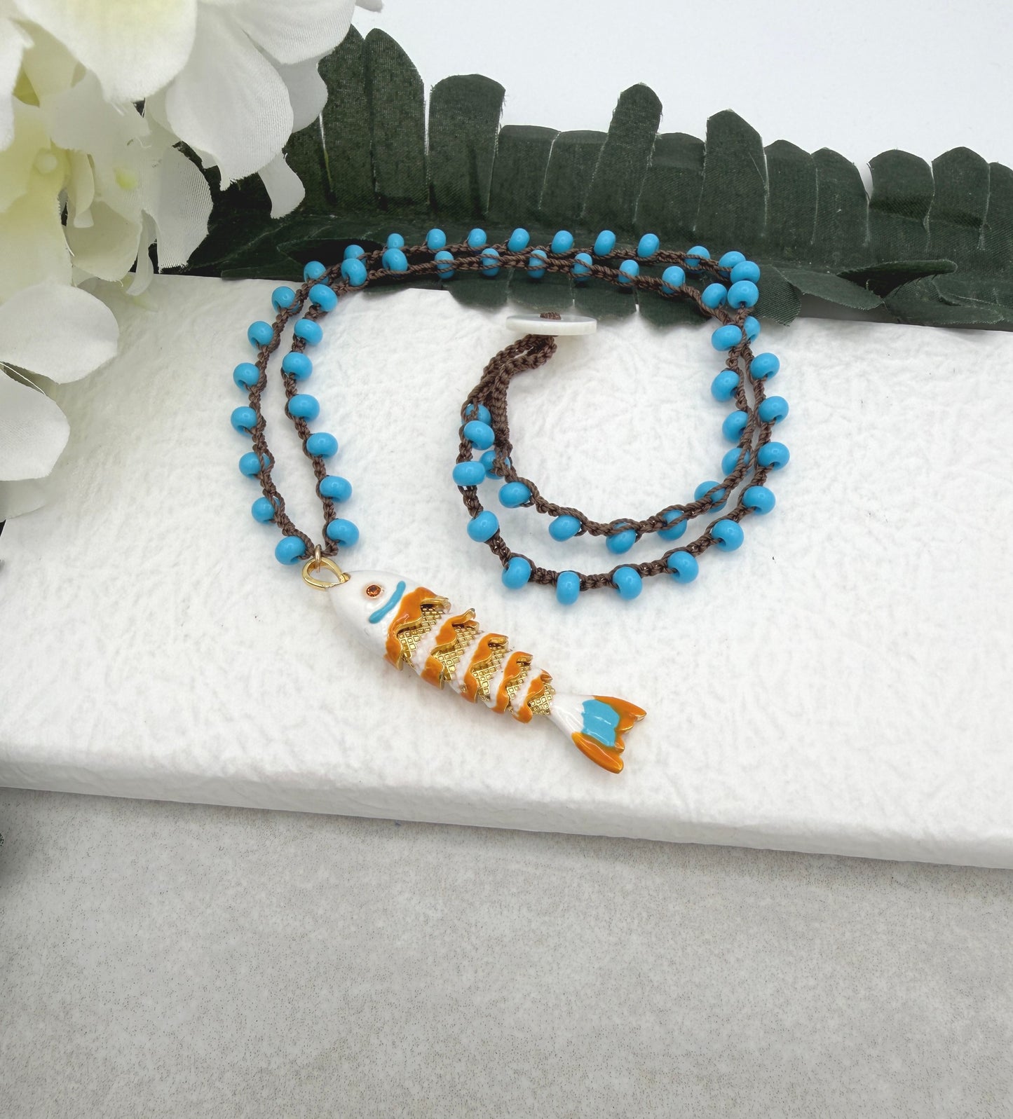 Crocheted Necklace with a Brown Cord, Turquoise Glass Beads and a White, Orangle Enameled Fish Charm SN-705