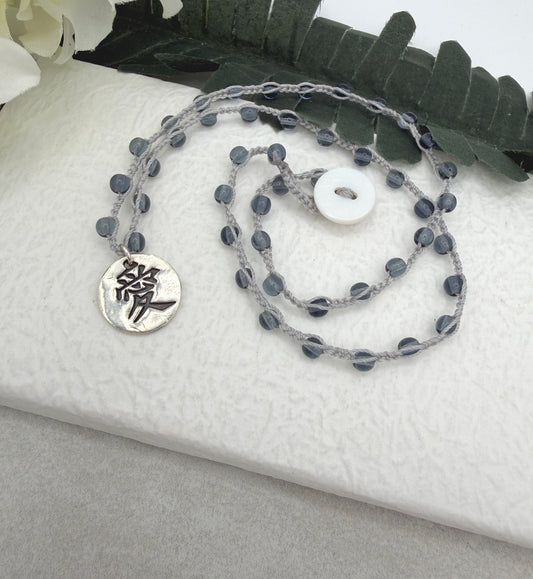 Crocheted Necklace with a Light Gray Cord, Montana Blue Glass Beads and a Round, PMC Pendant with the Symbol for Love SN-708